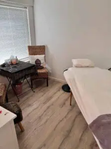 Rolig behandlingstue med massagebræt, stearinlys og afslappende atmosfære for heling; ideel for krystal- og healerterapi.